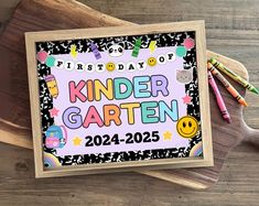 a sign that says kinder garden on it next to some crayons and markers