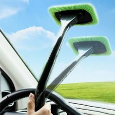 a hand holding the steering wheel of a car with a microfiber on it