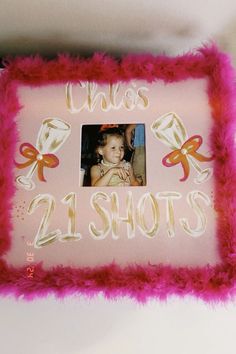 a pink cake with a photo on it and the words'2 shots'in gold lettering