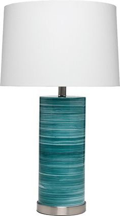 a table lamp with a white shade on it and a blue striped glass vase underneath