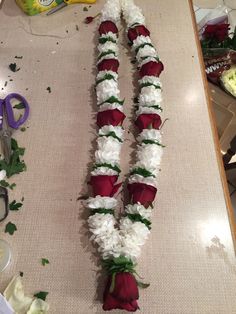 flowers are laid out on the table to be made into garlands