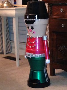 a christmas decoration sitting on the floor next to a dresser