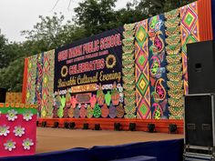 the stage is decorated with colorful fabric and flowers