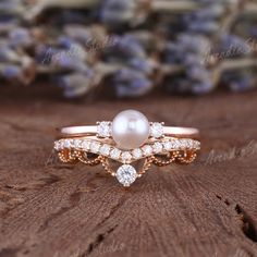 a close up of a ring on a piece of wood with flowers in the background