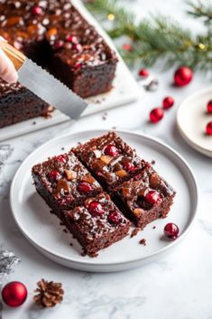 someone is cutting into some brownies on a plate with cranberry toppings