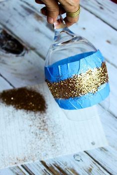 someone is pouring something into a glass with gold flakes on it and sprinkles