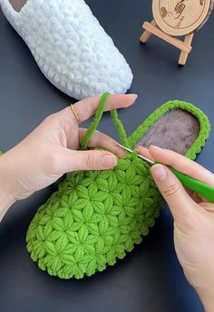 someone is crocheting the bottom part of a green slipper