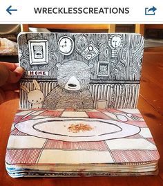 an open book with a drawing of a bear on the front and back cover sitting on top of a wooden table