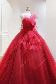 This bold red ball gown wedding dress is accentuated with a large front ruffled bow, puffy long skirt. Red Strapless Gown For Quinceanera, Red Tulle Gown For Quinceanera, Red Strapless Ball Gown With Fitted Bodice, Red Ruffled Ball Gown For Party, Red Ruffled Dress For Debutante Ball, Elegant Red Ball Gown With Ruffles, Red Tulle Ball Gown With Ruffles, Red Strapless Ball Gown For Wedding, Red Ruffled Wedding Gown