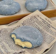 blue and yellow pastries sitting on top of an open newspaper