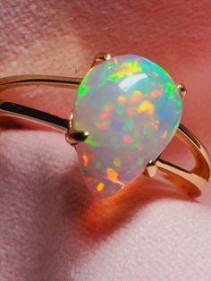 14k solid gold opal ring, beautiful opal with many bright rainbows adorning it mounted on a gold split shank ring. The ring is light and easy to wear and comes in 6 sizes I can swap the stone into. 14k Yellow Gold Opal Promise Ring, Fine Jewelry Yellow Gold Opal Ring, Yellow Gold Opal Ring In Fine Jewelry Style, Fine Jewelry 14k Gold Pear-shaped Opal Ring, 14k Gold Pear-shaped Opal Ring Fine Jewelry, 14k Gold Pear-shaped Opal Ring, Yellow Gold Opal Birthstone Ring, Pear-shaped 14k Gold Opal Ring Fine Jewelry, Pear-shaped 14k Gold Opal Ring