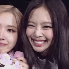 two young women are smiling and holding teddy bears