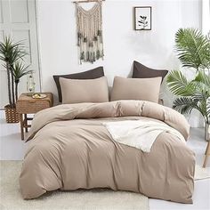 a bed with beige sheets and pillows in a room