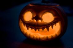 a carved pumpkin with glowing eyes and teeth