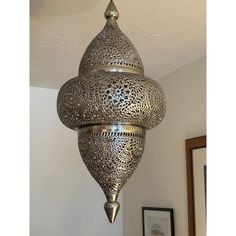 an ornate metal light fixture hanging from the ceiling