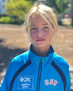 a young blonde girl in a blue jacket