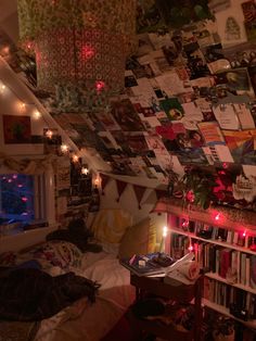 a bedroom with many pictures hanging on the wall and lights strung from the ceiling above it