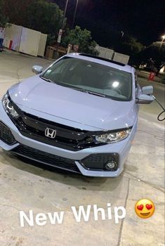 the front end of a blue honda civic with an emoticive message on it