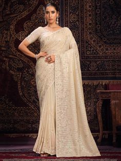 Elevate your ethnic wardrobe with our lovely off-white sequins georgette traditional saree with blouse, a stunning ensemble perfect for weddings, festivals, parties, and special occasions.
Crafted in vibrant off-white color, this saree is adorned with intricate sequin work, thread work, and zarkan work, adding a touch of elegance and sophistication to your look.
The off-white georgette saree comes with a 5.50-meter length, allowing you to drape it in various styles to suit your preference. The u White Georgette Saree, Designer Sarees Wedding, Net Blouses, Latest Designer Sarees, Lehenga Style, Indian Sarees Online, Silk Saree Blouse, Designer Sarees Online, Bridal Sarees