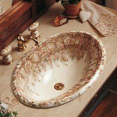 a bathroom sink sitting on top of a counter next to a vase filled with flowers