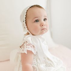 Designed from our studio in USA and imported An elegant full-length Christening gown. This gown is hand-crafted down to the last detail. Made from a silk and cotton blend in ivory featuring a Venice inset for a detailed beauty not found on most gowns. Lace bodice with cap sleeves add to the uniqueness of the gown. Ties in back with a silk sash. Includes matching lace bonnet so she has her complete look. 30% Silk / 70% Cotton Ivory Cotton Venice inset Silk sash tie Button closure Lined Elegant Cream Fitted Baptism Dress, Elegant Fitted Off White Baptism Dress, White Gown With Lace Trim And Fitted Bodice, Classic White Dress With Lace Bodice, Classic White Gown With Lace Trim, Fitted Cotton Wedding Gown, Fitted White Gown With Lace Trim, White Fitted Gown With Lace Trim, Classic Off-white Wedding Dress