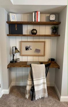 a room with some shelves and towels on the shelf next to it is an empty chair