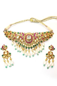 This Natural Ruby with Pearl and Emerald Necklace Set is a dazzling example of luxury and craftsmanship, meticulously designed to highlight the beauty of natural gemstones and the elegance of traditional jewelry. Crafted in 18k gold, this necklace is a masterpiece that showcases a harmonious blend of rubies, pearls, emeralds, and Polki diamonds. The necklace features vivid natural rubies, their deep red hue radiating passion and elegance. These rubies are perfectly complemented by the rich green of the emeralds, creating a striking contrast that is both eye-catching and sophisticated. Interspersed between the rubies and emeralds are lustrous pearls, adding a touch of softness and refinement to the piece. The pearls' subtle sheen enhances the necklace's overall elegance, balancing the bold Festive Pearl Necklace With Gemstone For Wedding, Multicolor Pearl Jewelry With Gemstones, Elegant Kundan Pearl Pendant Necklace, Elegant Multi-stone Kundan Necklace For Wedding, Exquisite Gemstone Jewelry For Festive Season, Elegant Multi-stone Gold Jewelry Sets, Exquisite Festive Gemstone Jewelry, Elegant Gold Multi-stone Jewelry Sets, Elegant Multi-stone Jewelry Sets As A Gift