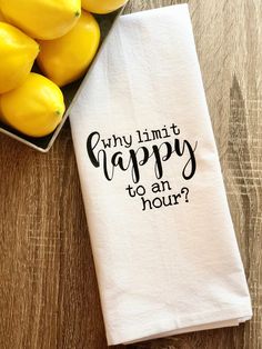 a dish towel that says, why limit happy to an hour? next to some lemons