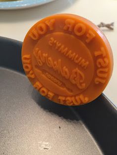 an orange gummy cookie sitting on top of a pan