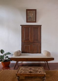 a living room with a couch, coffee table and potted plant on the floor