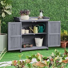 an outdoor garden with potted plants and gardening equipment on the shelf next to it