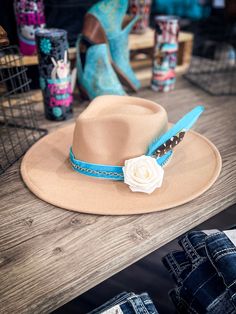 Turquoise Sahara - Camel Fedora Hat Introducing our Turquoise Sahara - Camel Fedora Hat, a regal piece put together by Bronco Western Supply. This Camel Fedora features a stunning Turquoise velvet ribbon hat band that elevates its charisma. Embellished with a rose gold chain and a beautiful cream rose, the hat captures the spirit of the wild west in an elegant way. Also included are bright turquoise and natural colored pheasant feathers that add a dash of rustic, vintage charm to the overall loo Turquoise Hat For Kentucky Derby Festival, Turquoise Hat For Kentucky Derby And Country Events, Turquoise Bohemian Hat For Kentucky Derby, Turquoise Curved Brim Hat For Country Events, Turquoise Hat For Festival And Kentucky Derby, Turquoise Hats For Kentucky Derby And Festivals, Turquoise Wide Brim Hat For Kentucky Derby, Turquoise Hat For Kentucky Derby, Turquoise Fedora For Western-themed Events