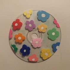 a cd with colorful flowers on it sitting on a white table next to a wall