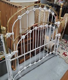 a white iron bed frame with gold posts