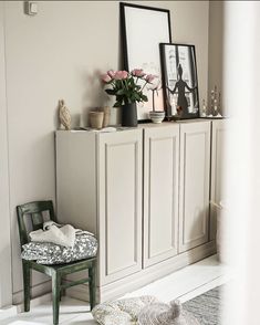 a chair sitting in front of a white cabinet