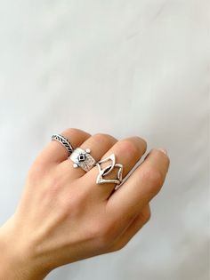 Discover the perfect set of handcrafted silver rings on Etsy. Embrace the harmonious essence of these three unique designs, each with their own distinct flair. The first ring showcases an asymmetrical charm, formed by two interconnected parts. The second ring, a wide band, captivates with a vibrant rhombus enamel centerpiece. Completing the set, a delicate leaf-inspired design adorns the slim band. Enjoy these adjustable rings both separately or combined, exclusively available at Christina Chris Unique Handmade Silver Heart Ring, Artisan Silver Stackable Rings As Gift, Artisan Sterling Silver Rings With Unique Variations, Handmade Silver Stackable Promise Rings, Bohemian Sterling Silver Ring, Handmade Bohemian Heart Ring Gift, Bohemian Handmade Heart Ring Gift, Handmade Silver Open Couple Rings, Artisan Handmade Silver Stackable Rings