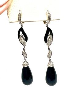 The Black Onyx and Diamond Drop Earrings in 14 karat white gold feature 2 polished pear-shaped black onyx drops measuring 2 1/2 inch long and weighing 10.5g. accented by 50 round brilliant diamonds weighing 0.50ctw with H-I color and SI1 clarity. Luxury Black Drop Jewelry, Black Teardrop Fine Jewelry Earrings, Black Drop Earrings For Formal Occasions, Van Nuys, Diamond Drop Earrings, White Gold Diamonds, Black Onyx, Round Brilliant, Pear Shaped