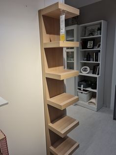 an empty shelf in the corner of a room with bookshelves and other items