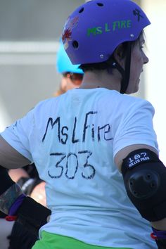 a woman wearing a purple helmet and green shorts