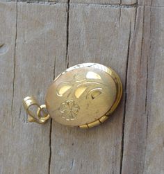 "This small locket has general is in excellent condition. It closes securely and is almost ~5/8\" long including bail. Item is sold as-is. We welcome haggling in this shop!" Antique Gold Locket Necklace Stamped 14k, Vintage Etched Oval Pendant Locket Necklace, Gold Etched Victorian Locket Necklace, Etched Gold Pendant Locket Necklace, Gold Etched Pendant Locket Necklace, Antique Engraved Locket Necklace With Flower Pendant, Vintage Gold Locket Necklace Stamped 14k, Vintage Gold Etched Locket Necklace, Antique Engraved Flower Pendant Locket Necklace