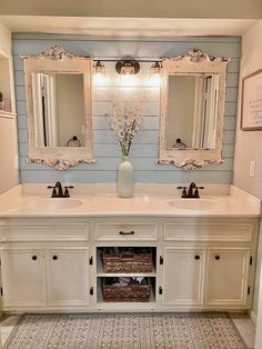 a bathroom with double sinks and two mirrors on the wall above them is decorated in blue and white