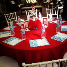 a red table topped with water bottles and place settings