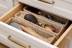 an open drawer with wooden utensils and other kitchen items in the bottom drawer