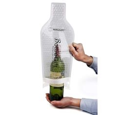 a person holding a wine bottle wrapped in plastic