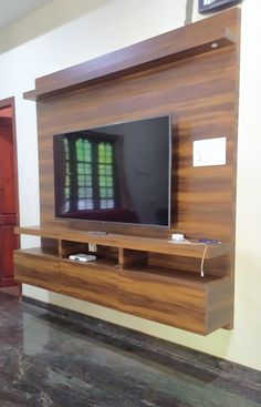 a flat screen tv mounted to the side of a wooden entertainment center in a living room