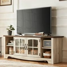 a flat screen tv sitting on top of a wooden entertainment center in a living room