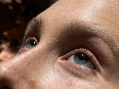 a close up of a person's face with blue eyes