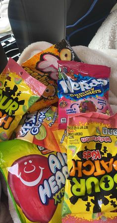 several candy bags are piled on top of each other in the back of a car