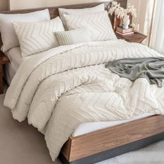 a bed with white comforter and pillows in a bedroom