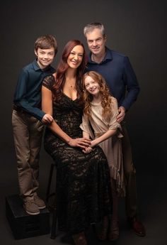 a family posing for a photo in front of a black background